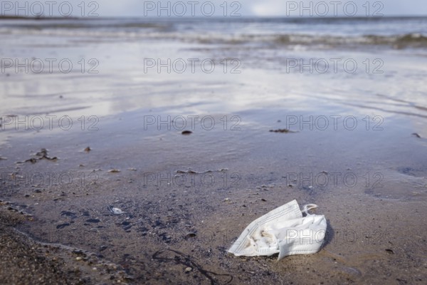 Discarded face mask on the beach Baltic Sea