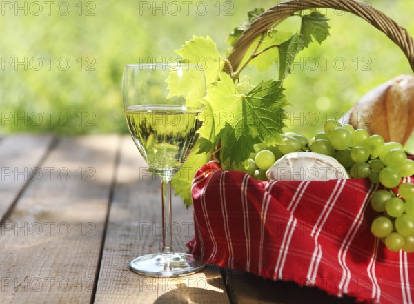 Cheese, grapes, bread and two glasses of the white wine outdoors