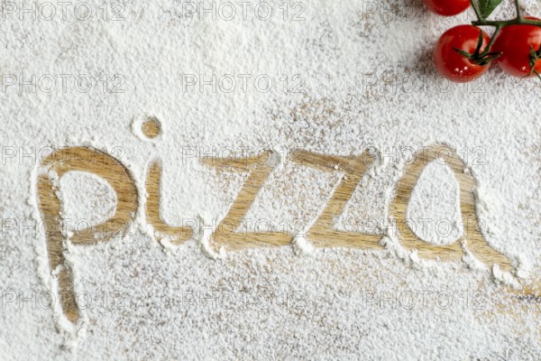 Top view pizza word written flour