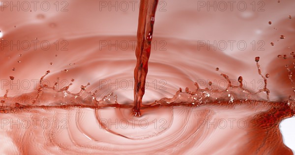 Red Wine being poured against White Background