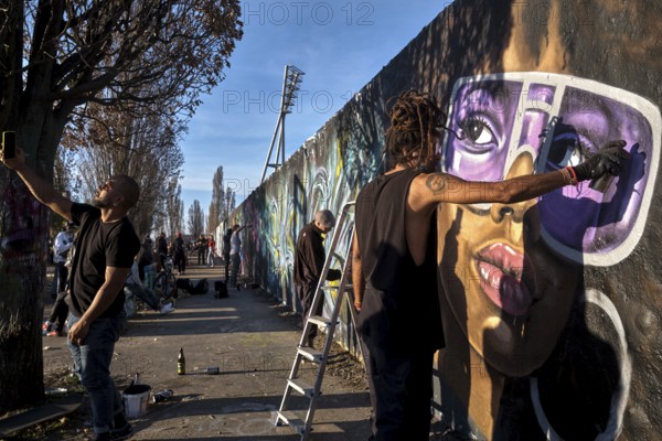 Germany, Berlin, 27. 03. 2022, Sunday afternoon Mauerpark, graffiti wall, graffiti artist Eme Freethinker at work, mobile phone photo, Europe