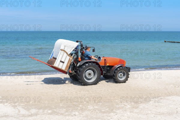 The beach chair rental place their baskets by tractor on the beaches of the Baltic Sea near Graal M