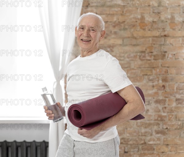 Medium shot senior man holding yoga mat