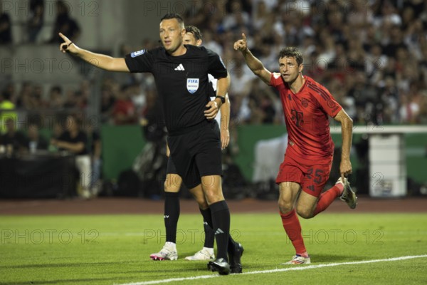 Football match, Thomas MÜLLER FC Bayern Munich celebrates his goal with raised left arm and index finger to make it 0:2, left, referee Sven JABLONSKI pointing to the centre, Donaustadion football stadium, Ulm, Germany, Europe