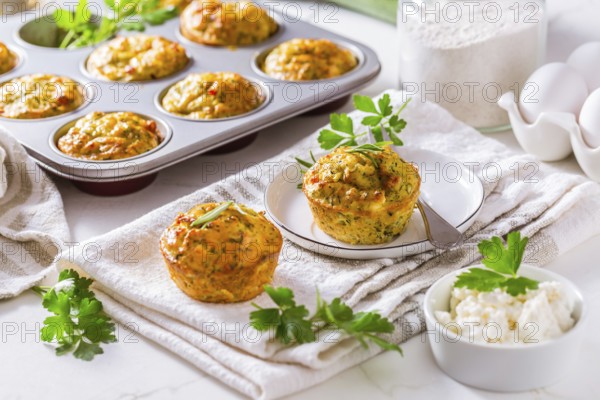 Delicious homemade zucchini muffins with feta cheese on white kitchen table