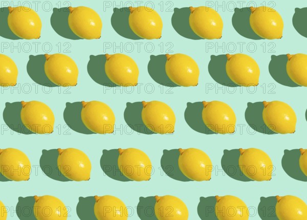 Fresh yellow whole lemons on minimal blue background on bright sun light with hard shadows pattern summer background flat lay from above, citrus food composition, space for text