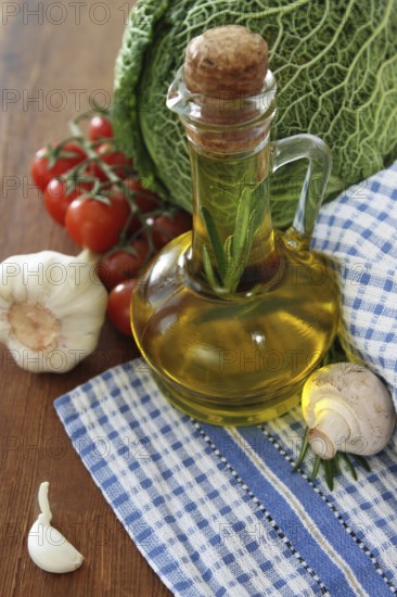 Vegetables still life with olive oil, mushrooms on wooden background