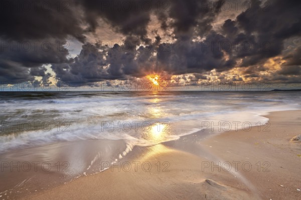 Colorful sunrise on beach of baltic sea in germany