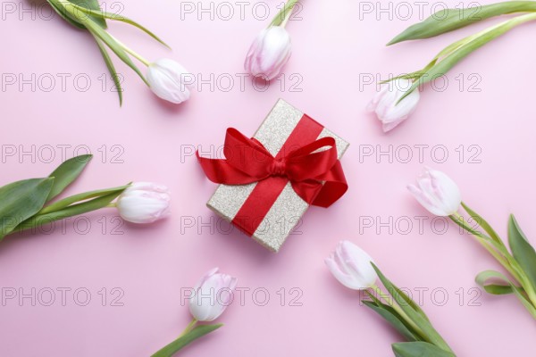 Tulips and gift box on pink background flat lay, romantic card template