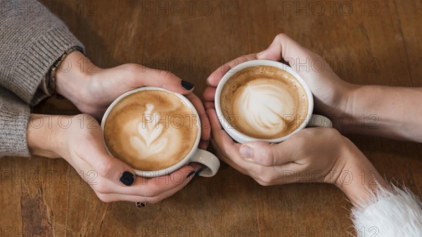Women holding cups coffee table