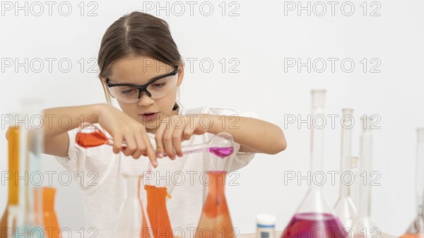 Girl doing chemistry experiments with safety glasses