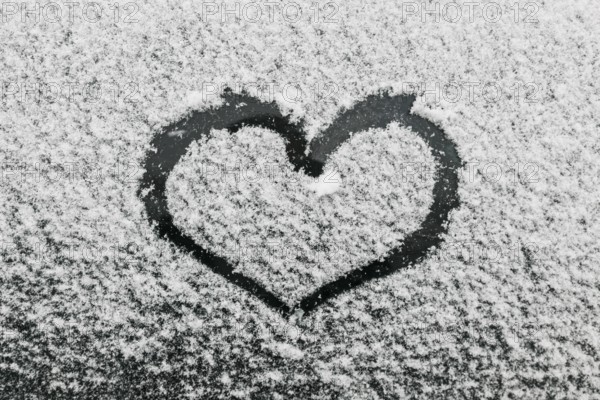 Heart shape snowy glass during winter day