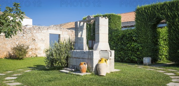 Summer season in Italy. Desing water well in an elegant garden