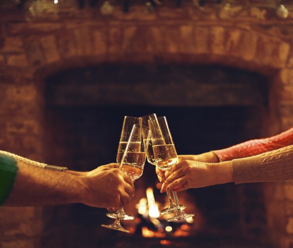People clinking champagne glasses while gathering around fireplace in country house, cropped shot. Friends drinking alcohol, celebrating event near fire at home. selective focus. Celebration concept