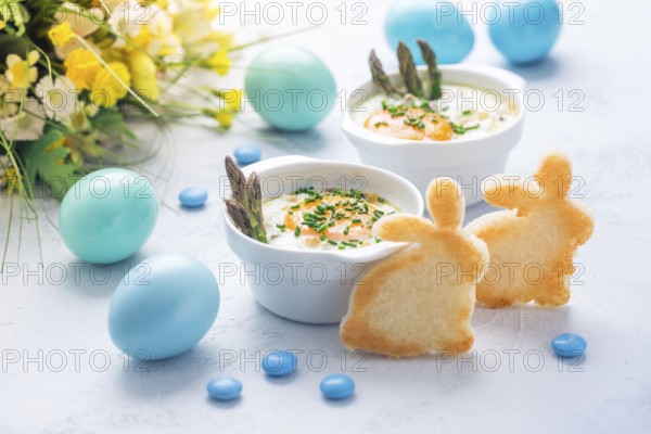 Shirred eggs (Oeuf cocotte) or baked eggs with green asparagus with Easter toast bunny and eggs