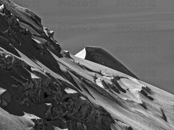 Black and white image of a snow-covered, jagged mountain peak with striking contrasts, Mont Blanc. Chamonix