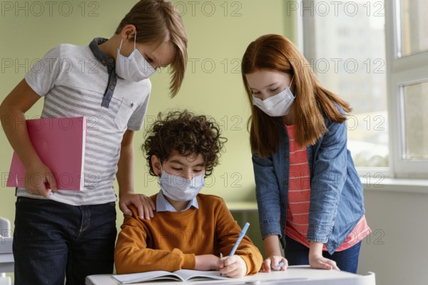 Front view children with medical masks learning school
