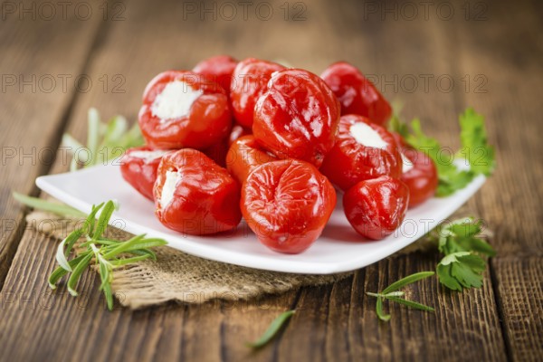 Fresh made Red Pepper (stuffed with cheese) on an old and rustic wooden table (selective focus, close-up shot)