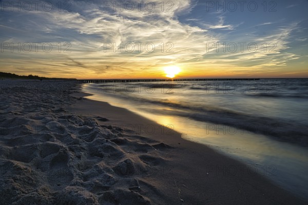 Sunset on the beach of zingst on the baltic sea. with view of the sea and beautiful colors of the sky