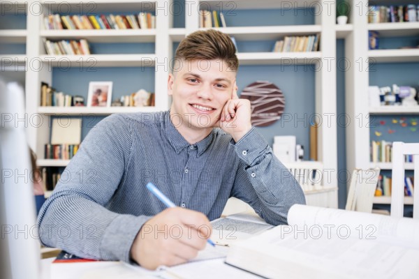 Student sitting with books pen library