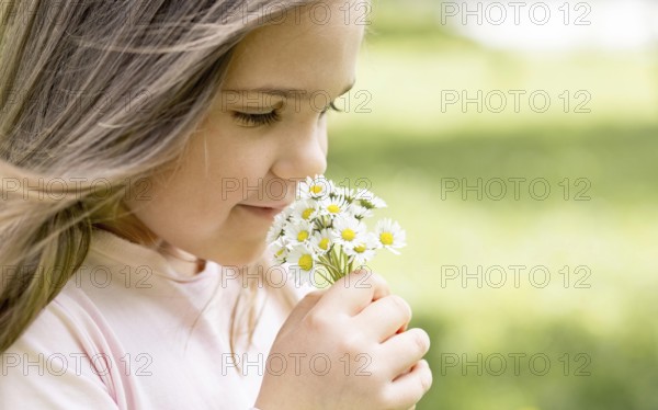 close up girl smelling bouquet field flowers
