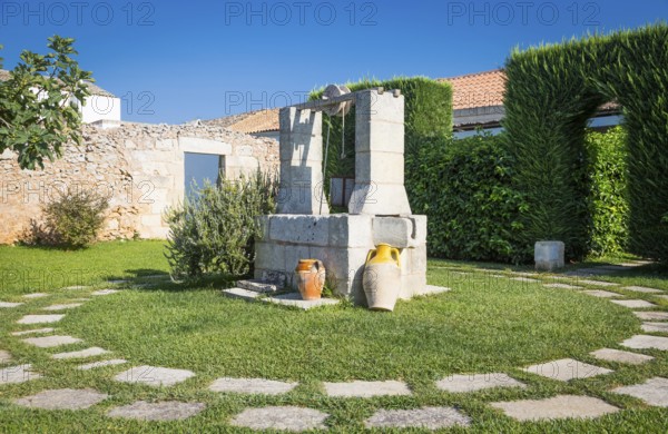 Summer season in Italy. Desing water well in an elegant garden