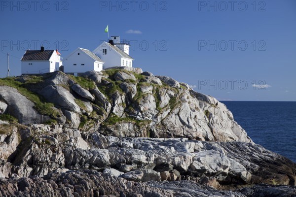 Coastal cliffs and the lighthouse, Henningsvaer, Henningsvær, Heimöya, Heimøya, Lofoten, Nordland, Northern Norway, Norway, Europe