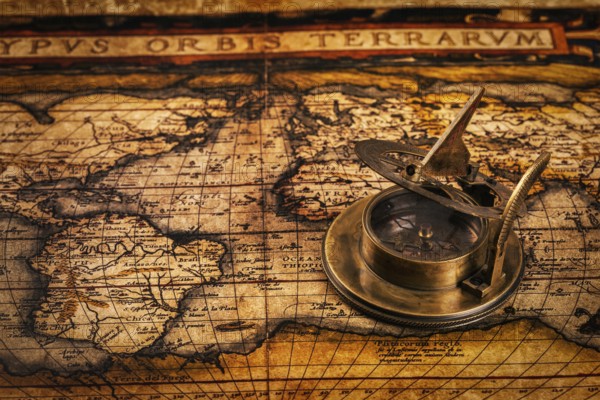 Travel geography navigation concept background, old vintage retro compass with sundial on ancient world map