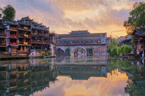 Chinese tourist attraction destination, Feng Huang Ancient Town (Phoenix Ancient Town) on Tuo Jiang River illuminated at night. Hunan Province, China, Asia