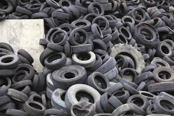 Old car tyres lie on stockpiles for recycling