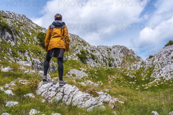 Mount Aizkorri 1523 meters, the highest in Guipuzcoa. Basque Country. A young hiker with a yellow jacket on top. Ascent through San Adrian and return through the Oltza fields