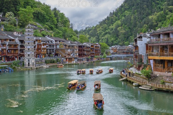 Chinese tourist attraction destination, Feng Huang Ancient Town (Phoenix Ancient Town) on Tuo Jiang River with Wanming Pagoda tower and tourist boats. Hunan Province, China, Asia