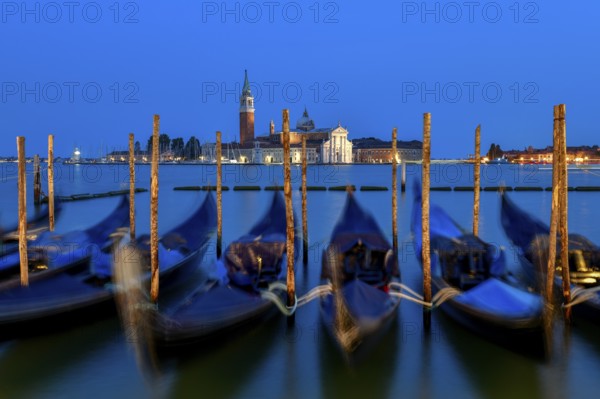 Venetian gondolas near St. Mark's Square in the evening light, blue hour, in the background the monastery of San Giorgio Maggiore, district of San Marco, Venice, Veneto region, Italy, Europe