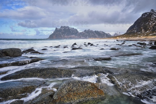 Rocks on beach of fjord of Norwegian sea in winter with snow. Utakliev beach, Lofoten islands, Norway, Europe