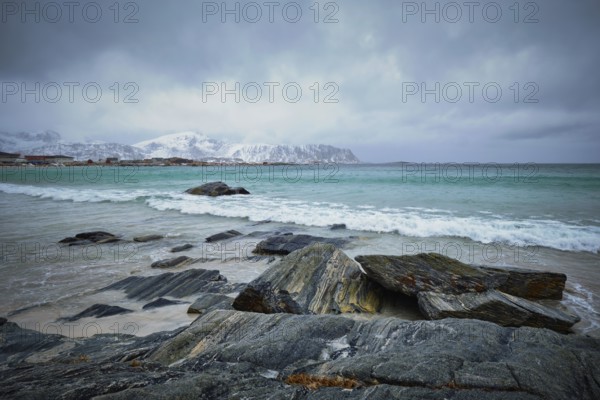Waves of Norwegian sea on rocky beach of fjord. Ramberg beach, Lofoten islands, Norway, Europe