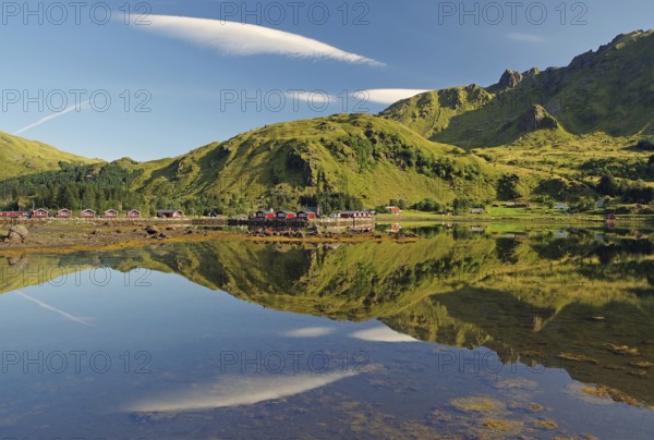 Wooden houses reflected in shallow fjord water, holiday cabins, Brustranda Sjøcamping, Valberg, Lofoten, Nordland, Norway, Europe