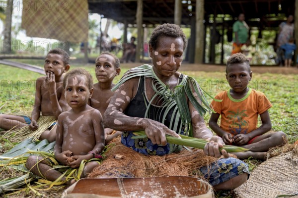 Local woman preparing banana leaves with roasted marrow of the Sago palm, village Pangoa, island Pangoa, Lake Murray, Western Province, Papua New Guinea, Oceania