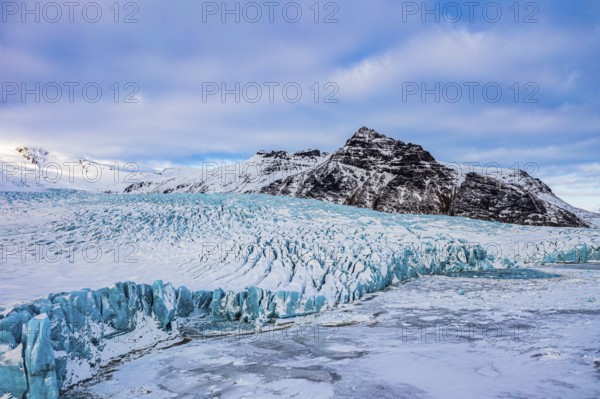 Snow-covered icebergs in the Fjallsarlon glacier lagoon, with the Öraefajökull glacier behind, drone shot, Sudurland, Iceland, Europe