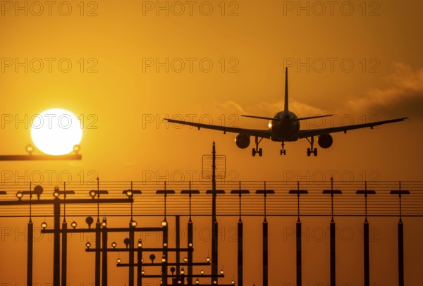 Aircraft approaching the main runway south, 05R/23L, runway lighting, approach aids, at Düsseldorf International Airport, sunset, North Rhine-Westphalia, Germany, Europe