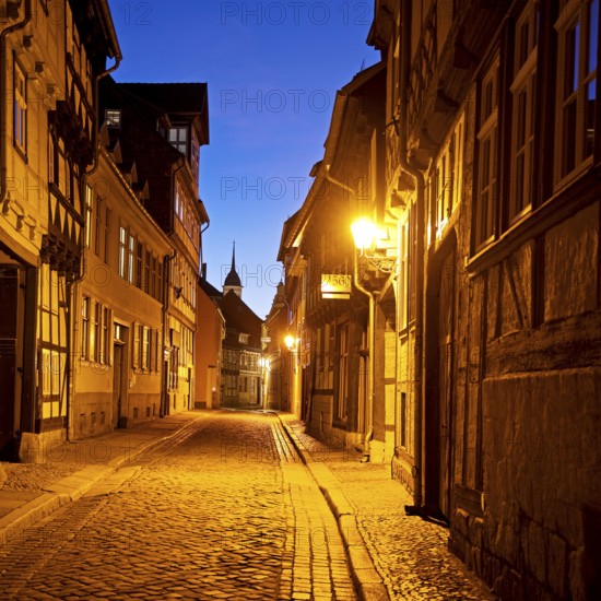 Half-timbered houses in a narrow street with cobblestones, Old Town in the evening, World Heritage City of Quedlinburg, Saxony-Anhalt, Germany, Europe