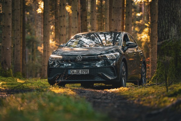 Black car on a forest path, surrounded by dense trees, car sharing vehicle Deer Mobility, electric car VW ID5, Black Forest, Germany, Europe