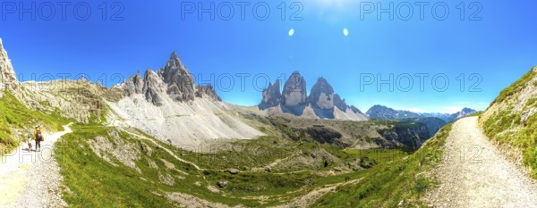 Panoramic. Hikers enjoying a sunny summer day on a scenic mountain trail near the iconic tre cime di lavaredo peaks in the italian dolomites