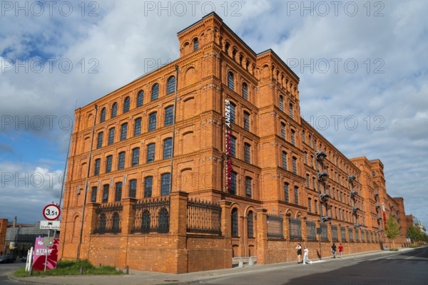 Large historic brick building under a blue sky with people passing by, Manufaktura, Lódz, Lodz, Lodz, Poland, Europe