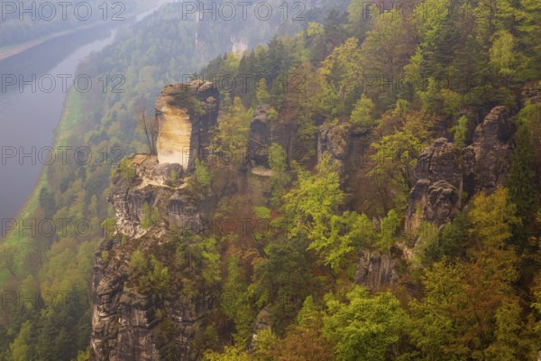 The bright lit Wartturm above the Elbe river seen from the Bastei rocks near the village of Rathen in Saxon Switzerland National Park, Saxony, Germany. On November 22, 2000 the Wartturm was the scene of a spectacular rockfall