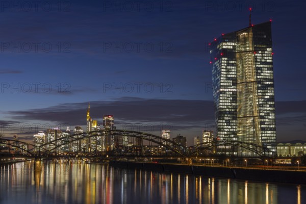 The lights in the offices of the European Central Bank (ECB) and in the skyscrapers of Frankfurt's banking skyline glow in the evening, Frankfurt am Main, Osthafen, Hesse, Germany, Europe