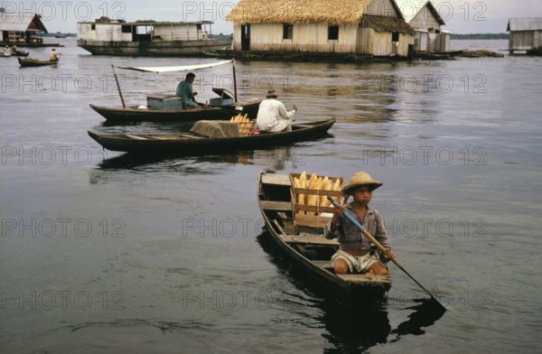 Small boats selling bread in informal huts built on logs, known as the floating city, Manaus, Brazil 1962