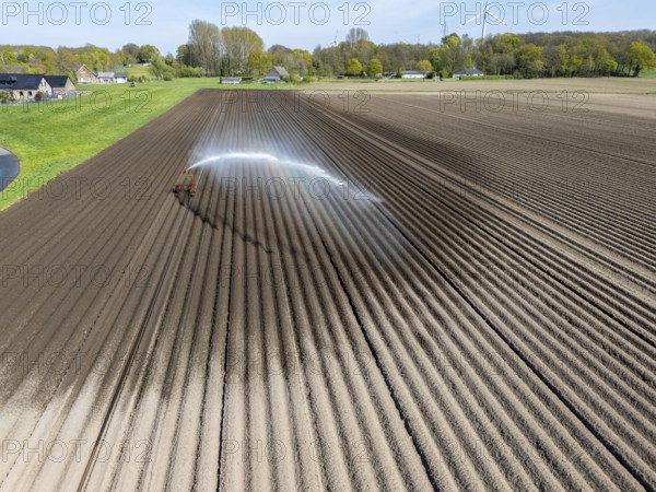 Artificial irrigation of a potato field in April, with a sprinkler system, long drought in spring makes this necessary, for the total of 7.5 hectares 3 full days are needed to get the necessary moisture for the freshly sown potato plants, south of Straelen, Lower Rhine, North Rhine-Westphalia, Germany, Europe