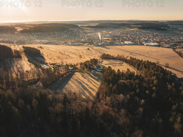 Forests and fields with a town in the background at sunrise, Althengstett sports club, Calw district, Germany, Europe
