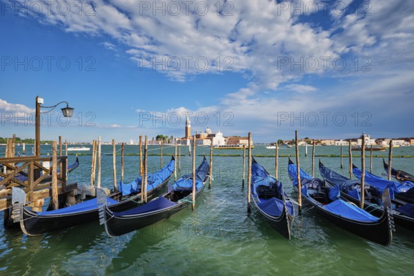 Gondolas and in lagoon of Venice by Saint Mark (San Marco) square with San Giorgio di Maggiore church in background in Venice, Italy, Europe