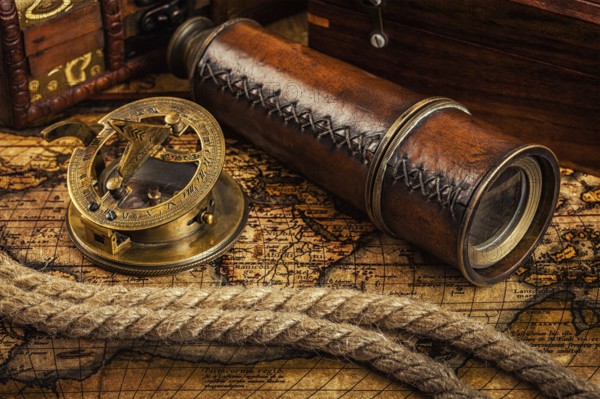 Travel geography navigation concept background, old vintage retro compass with sundial, spyglass and rope on ancient world map